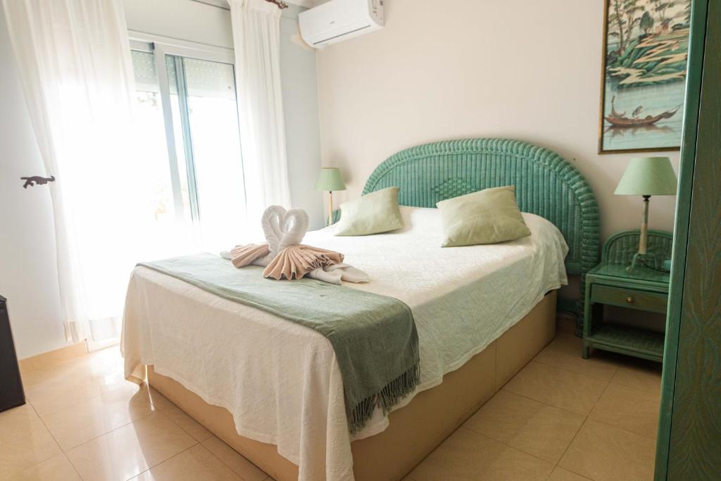 塔拉戈纳Paraíso Costa Dorada的一间卧室配有一张带绿色床头板的床
