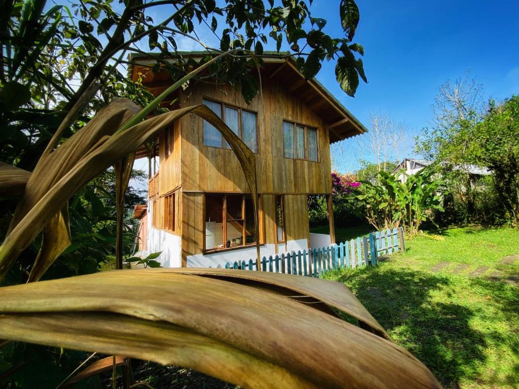 明多Inti Mindo Hostel的一座带围栏的院子中的小木房子