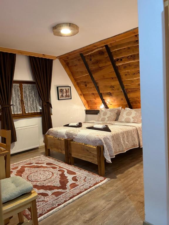 普利特维采湖普里特维采乡村小屋住宿加早餐旅馆的一间带一张床的卧室,位于带木制天花板的房间内