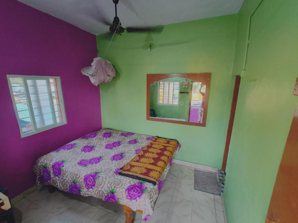 亨比Kiran River View Guest House的一间卧室配有一张紫色和绿色墙壁的床