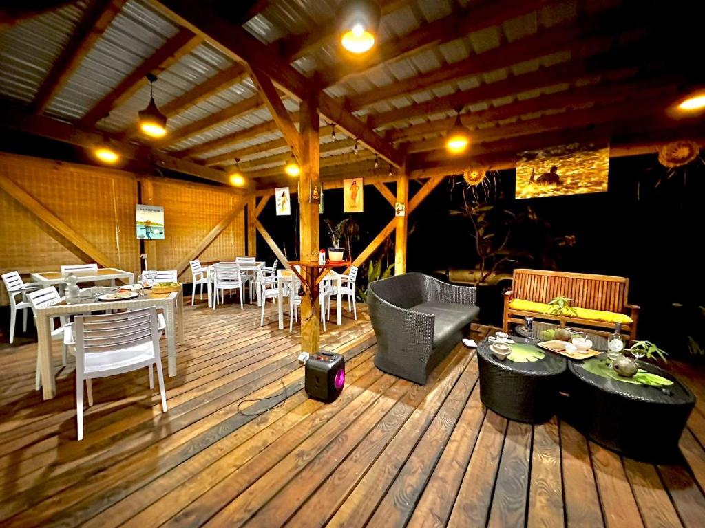 帕帕拉Manomano Lodge的一间铺有木地板并配有桌椅的餐厅