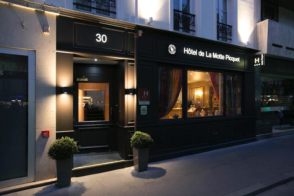 巴黎德拉莫特匹克酒店的建筑前有两株盆栽植物的商店