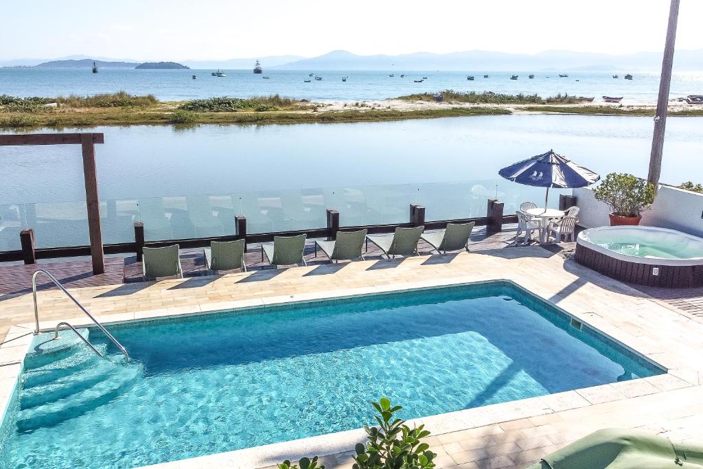 弗洛里亚诺波利斯哥斯达诺特彭塔卡纳斯酒店的一个带椅子的游泳池,享有海景