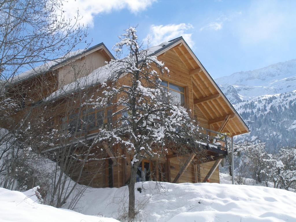 沃雅尼The Vaujany Mountain Lodge的雪地里的小木屋,有树