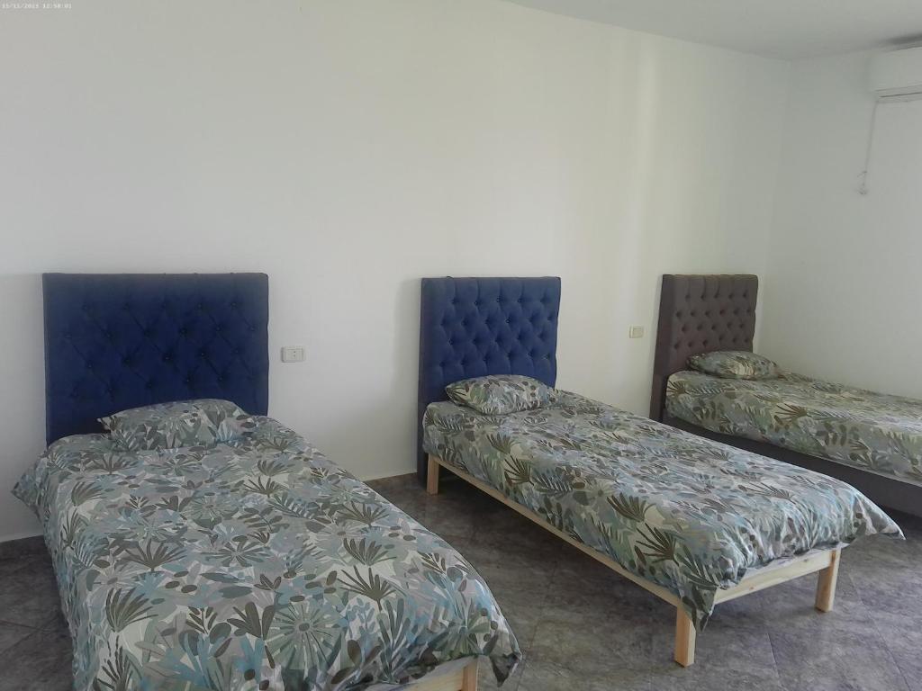 塔巴卡Villa Belle-Vue的配有蓝色床头板的客房内的两张床