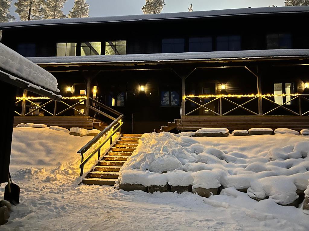 普哈圣山Porthos Ski Lodge的一座有楼梯和灯光的雪覆盖的建筑