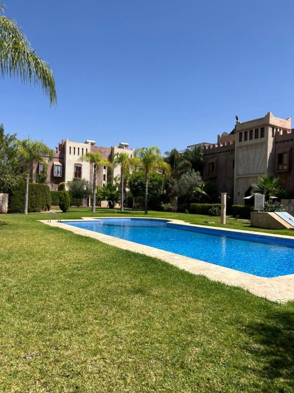马拉喀什Villa Riad Lana的游泳池位于几栋建筑旁的院子内