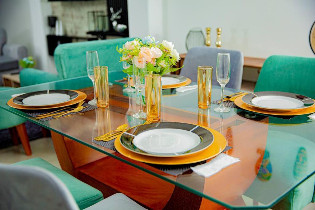 塔克纳Moderno y acogedor departamento的一张玻璃桌,上面有盘子和鲜花
