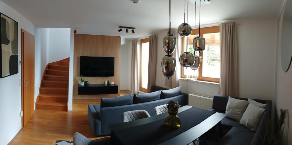 霍茨科波霍尔耶Pohorje Pearl Lux, 2-floor apartment的客厅配有蓝色的沙发和桌子