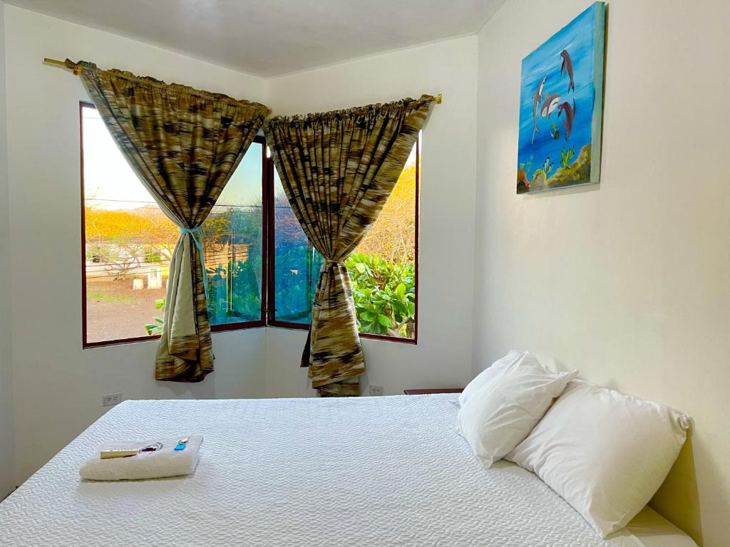 巴克里索莫雷诺港Hostal Vista al Mar的一间卧室设有一张床和两个窗户。