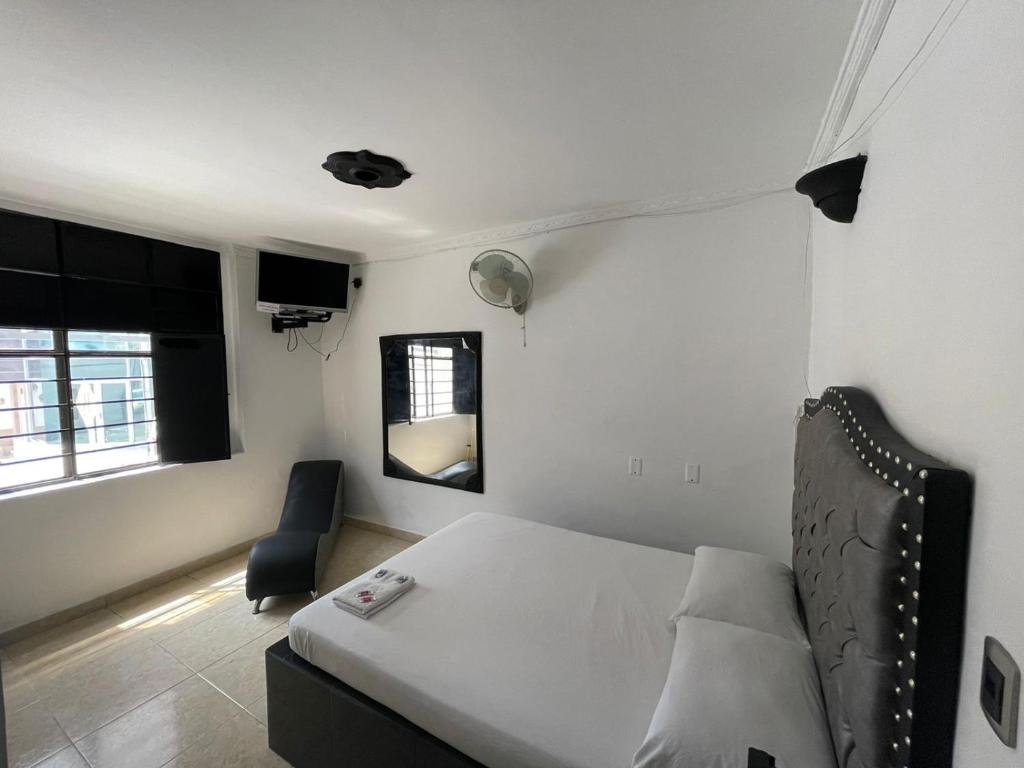 布卡拉曼加Residencia del Oriente的一间卧室配有一张床、一把椅子和镜子