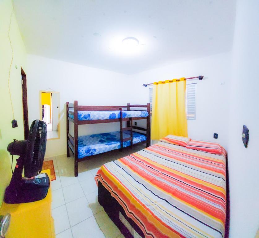 加利纽斯FLAT DA DANI Galinhos RN的一间卧室配有一张床和两张双层床。
