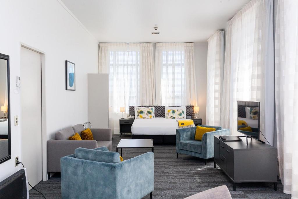 因弗卡吉尔奎斯特因弗卡吉尔服务公寓的客厅配有床、沙发和椅子