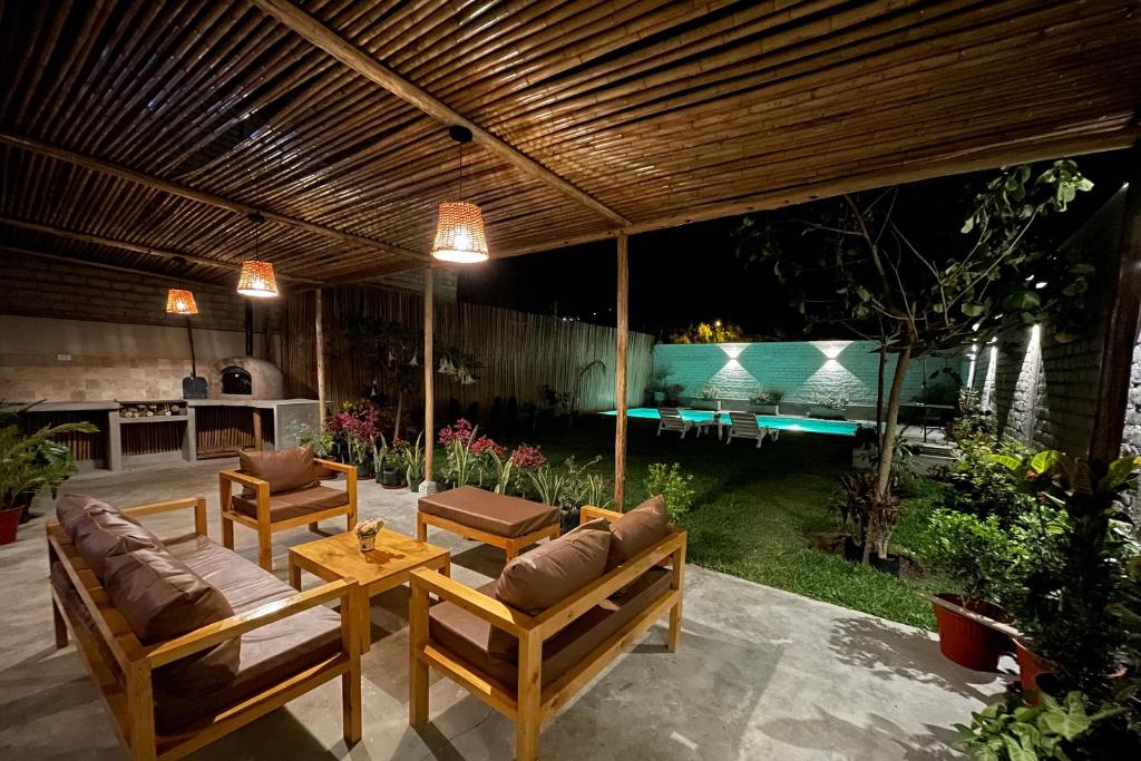 谢内吉亚区Hermosa casa de campo con piscina en Cieneguilla的天井配有两张沙发和一张桌子