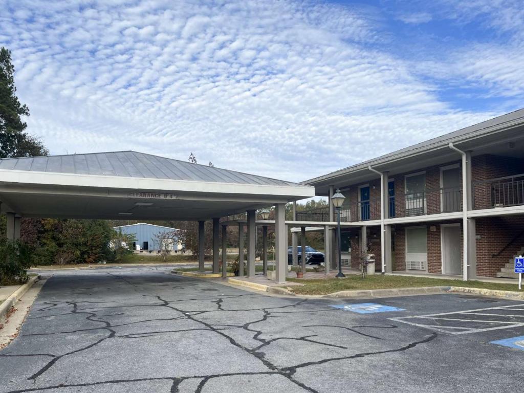 SandersvilleMotel 6 Sandersville, GA的大楼前的一个空停车位