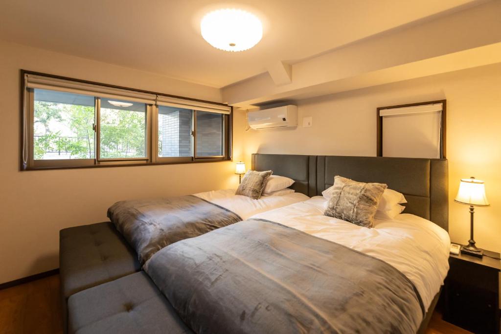 大阪Crest Otemae Stay - Self Check-In Only的配有两盏灯和窗户的客房内的两张床