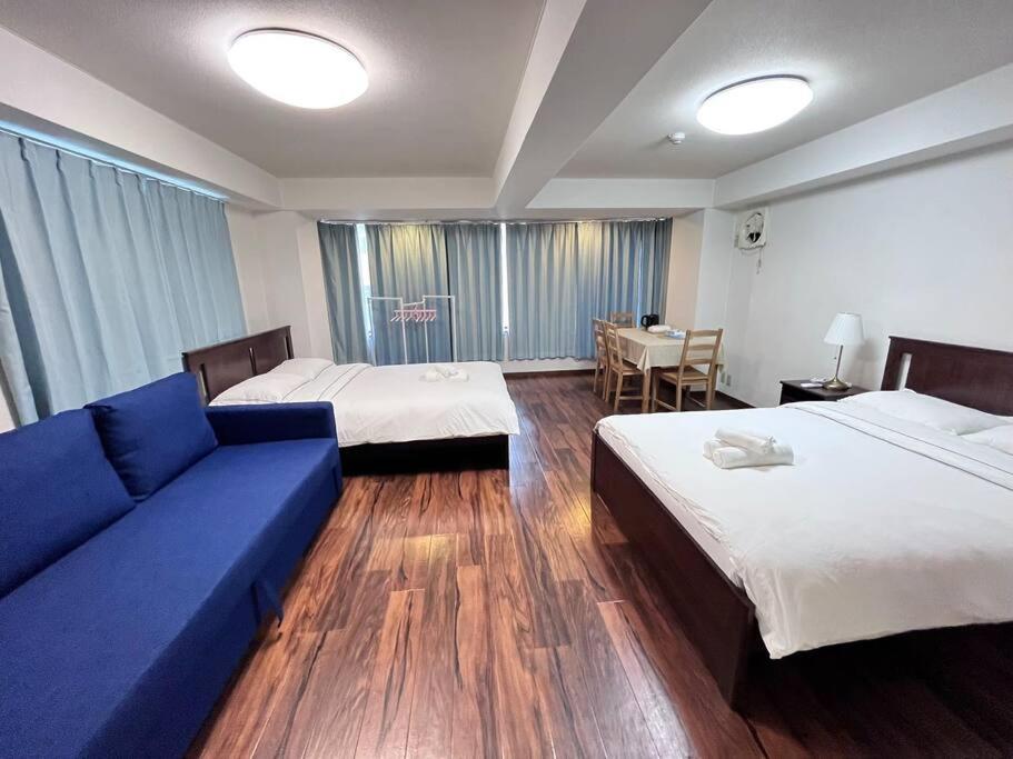 大阪日本橋電気街　DenDenTown大面積40㎡工レベ-タ-直結5F的酒店客房,设有两张床和一张蓝色的沙发
