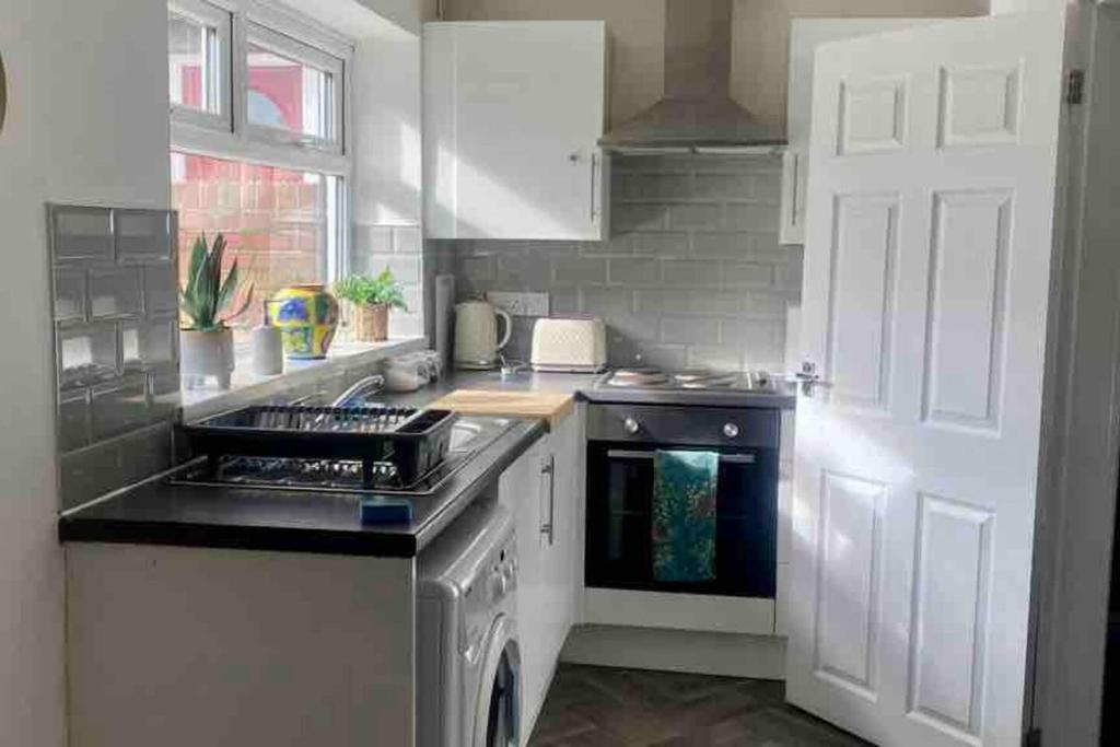 桑德兰Sunderland 2 bed easy access to whole city的厨房配有水槽和炉灶 顶部烤箱