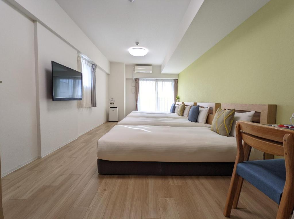 大阪ESLEAD HOTEL Namba South Ⅲ的一间酒店客房,房间内设有四张床