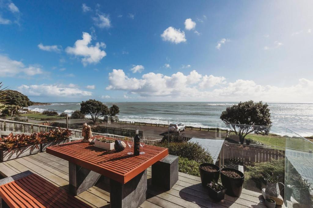 新普利茅斯Te Moana Waterfront的木甲板配有桌子,享有海景