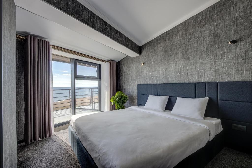 博斯特里Vzmorie Resort Hotel的一间卧室设有一张大床和一个大窗户