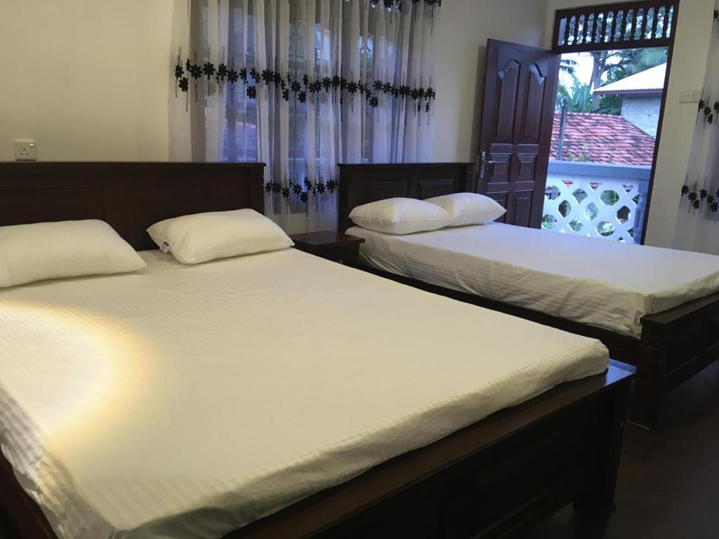 阿杭格默Sky Family Villa Ahangama的带窗户的客房内设有两张单人床。