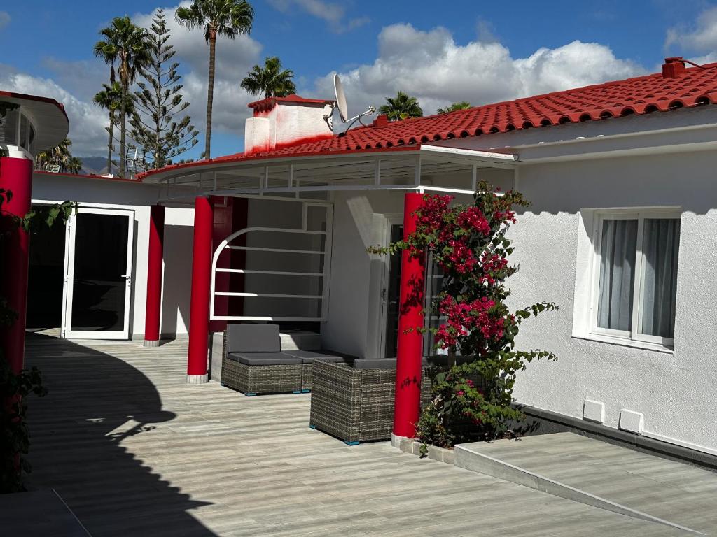 马斯帕洛马斯Paradise Resort - FKK Swinger & Nudist Couples Only的白色的房子,有红色的门和甲板