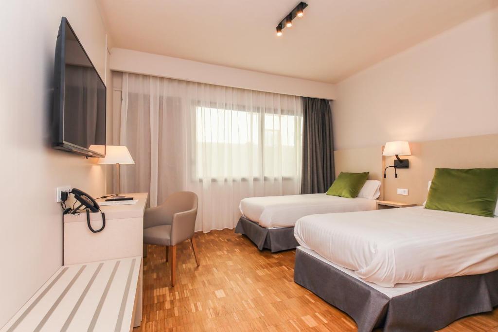 塔拉戈纳劳里亚酒店的酒店客房设有两张床和一台平面电视。