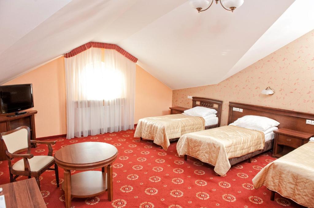 华沙阿卡迪亚皇家酒店 的酒店客房设有两张床和一张桌子。