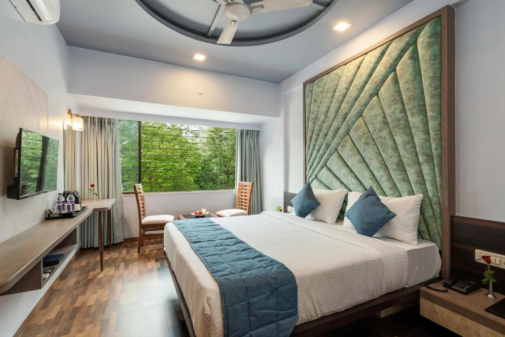 罗纳瓦拉Emerald Retreat的一间卧室配有一张床、一张书桌和一个窗户。