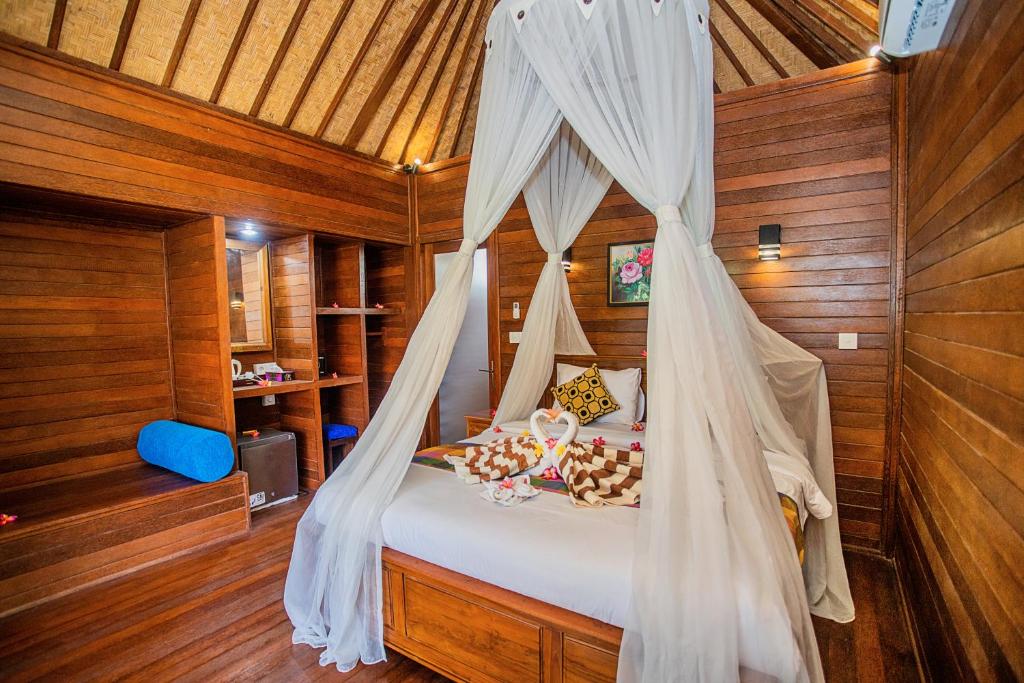 蓝梦岛Bagus Dream Beach Villa Lembongan的一间卧室配有一张带蚊帐的床