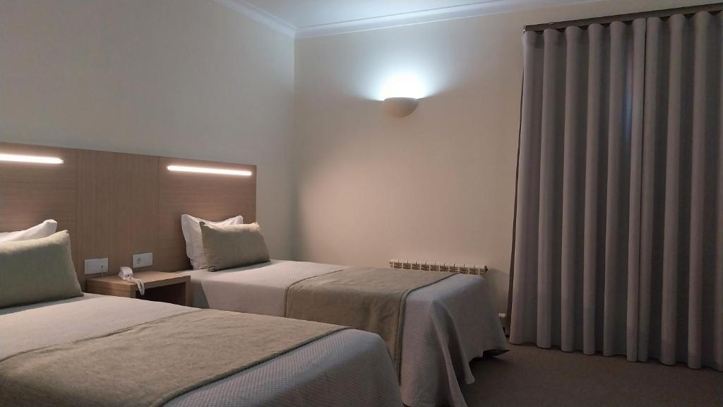 阿尔科巴萨圣玛丽亚酒店的酒店客房设有两张床和窗户。