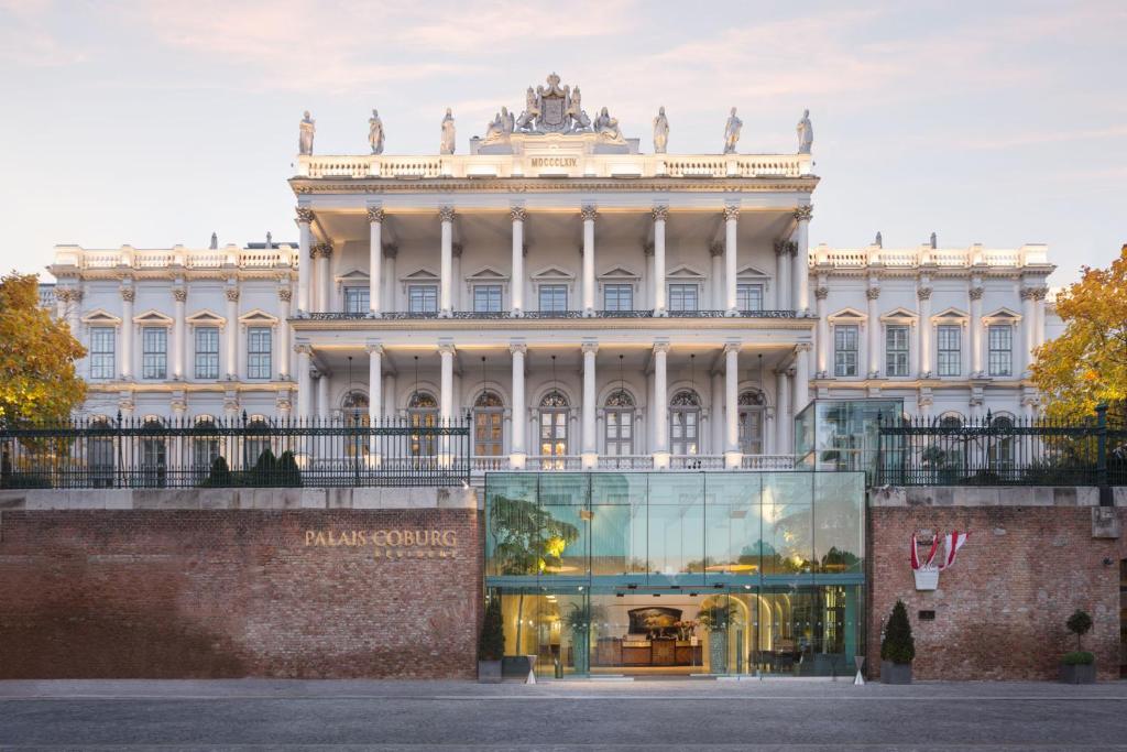 维也纳Palais Coburg Hotel的前面有玻璃店面的建筑