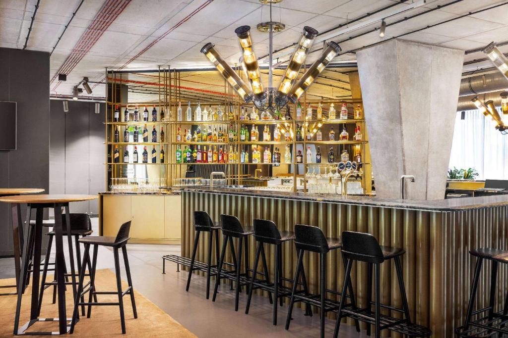 华沙Vienna House by Wyndham Mokotow Warsaw的餐厅的酒吧,带凳子