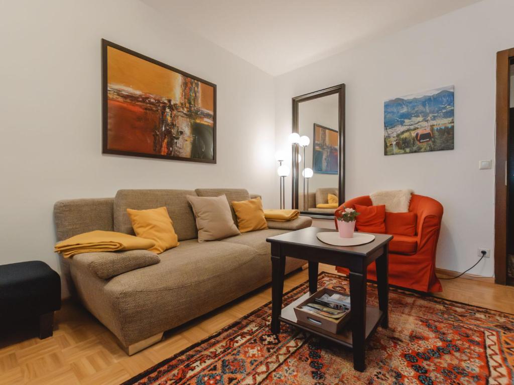 巴特霍夫加施泰因Apartment Orlic by Interhome的带沙发和橙色椅子的客厅