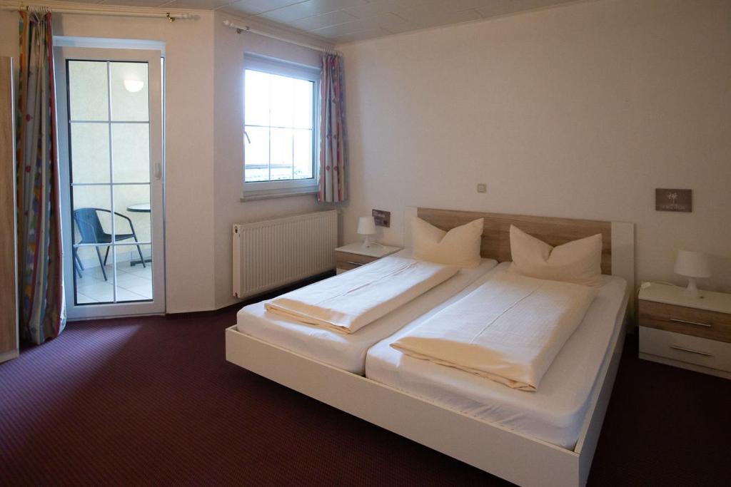 DolgesheimHotel Dolgesheim的卧室配有一张大白色床和窗户