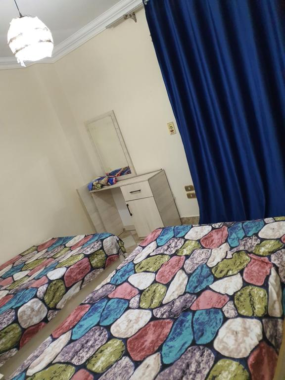 十月六日城فيلا بحمام سباحه的一间卧室配有一张带五颜六色棉被的床