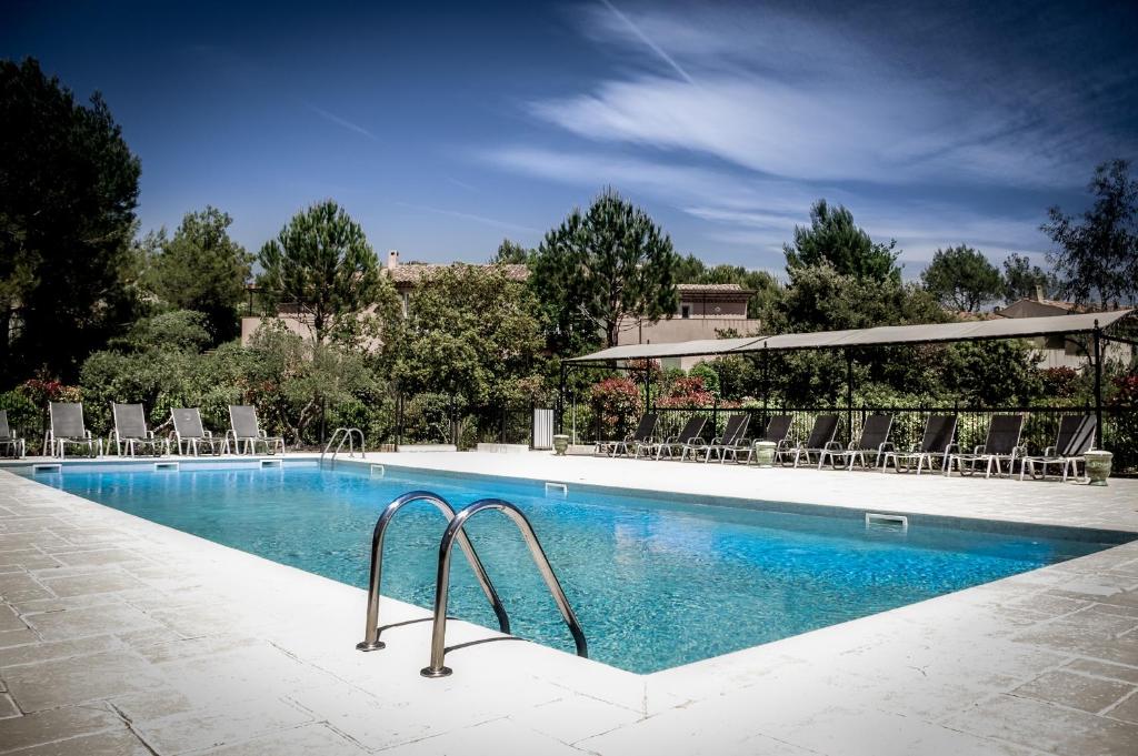 拉莫特Les Appartements et Maisons du Domaine de Saint Endréol Golf & Spa Resort的一个带椅子的大型游泳池
