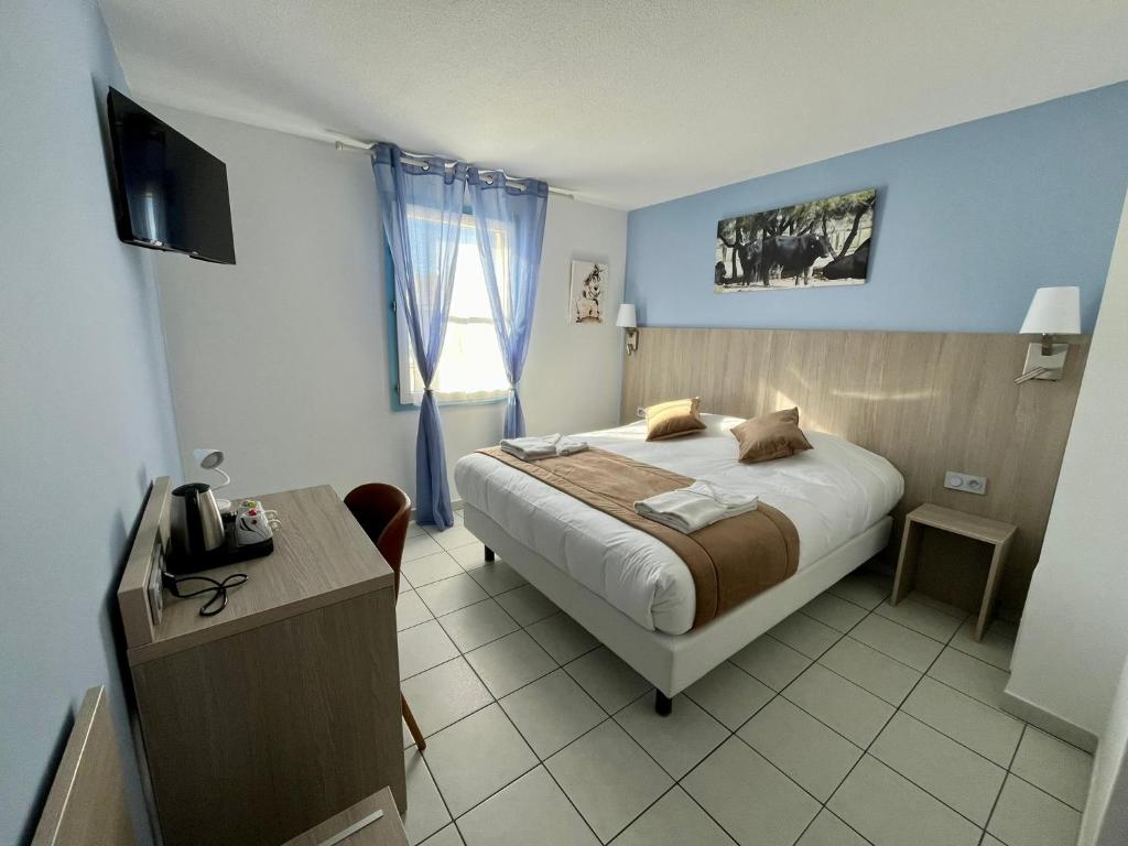 圣马迪拉莫阿卡兹酒店的一间卧室配有一张床、一张书桌和一台电视
