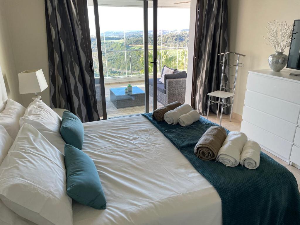 卡萨雷斯Superior apartment for golf, sea and nature lovers的一张带毛巾和枕头的大型白色床
