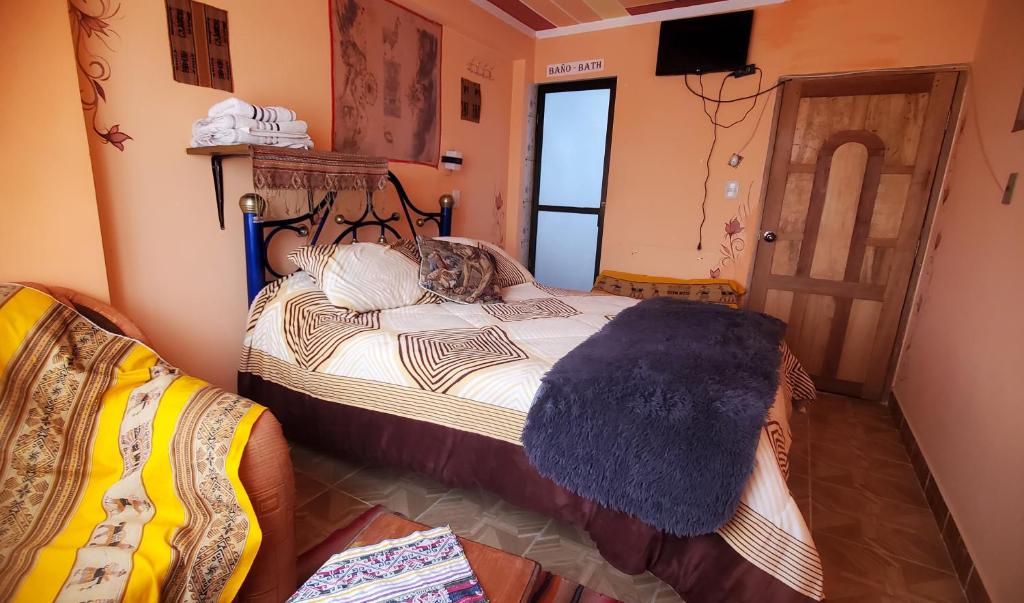 乌尤尼Hostal Golden Quinua的一间卧室配有一张带蓝色毯子的床