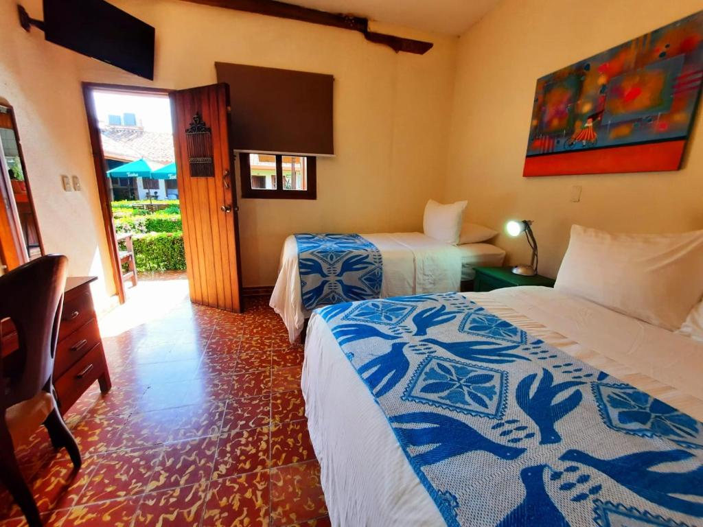 莱昂Hotel La Posada del Doctor的酒店客房设有两张床和电视。