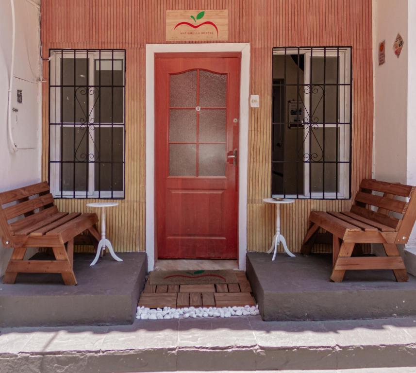 里约热内卢Matianellu Hostel的两个长椅坐在红门前