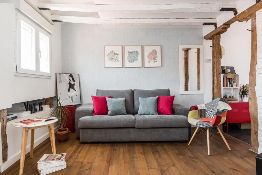马德里Charming La Latina Home的客厅配有灰色沙发和红色枕头