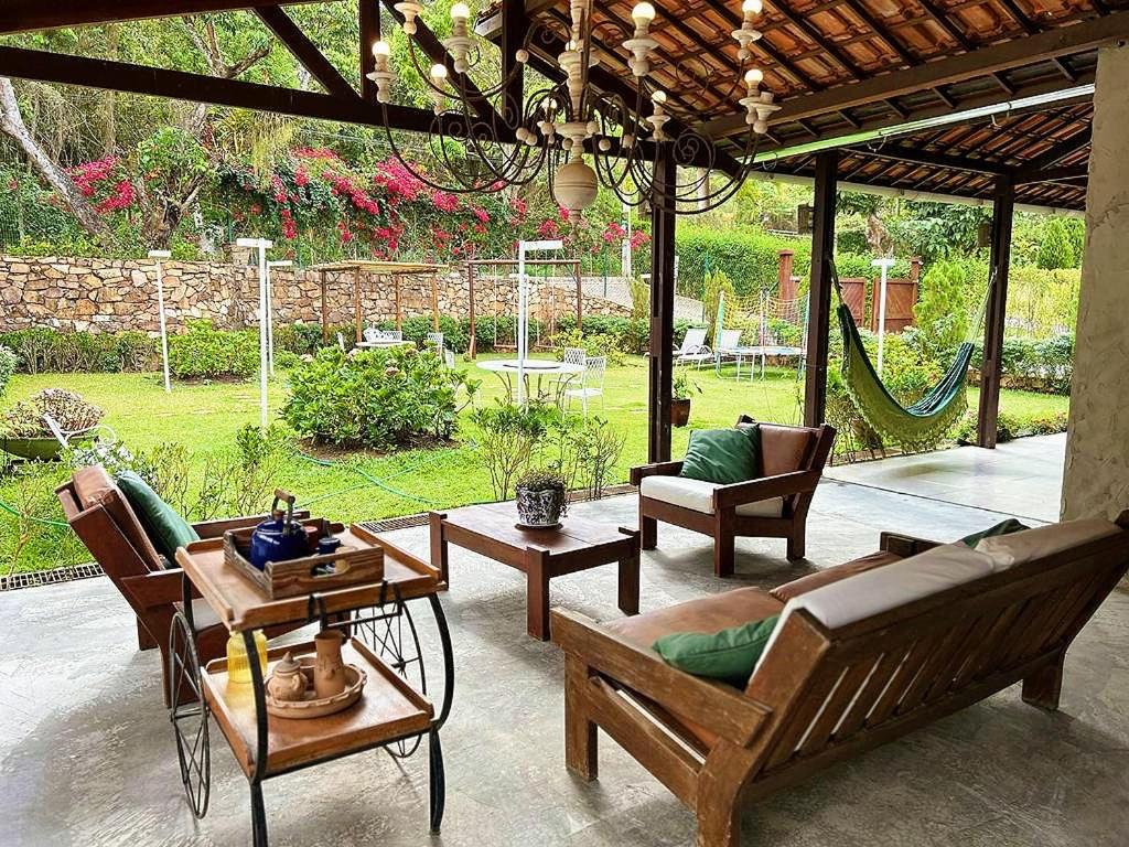 瓜拉米兰加Pousada Monte Flor Guaramiranga CE的庭院配有椅子、沙发和桌子