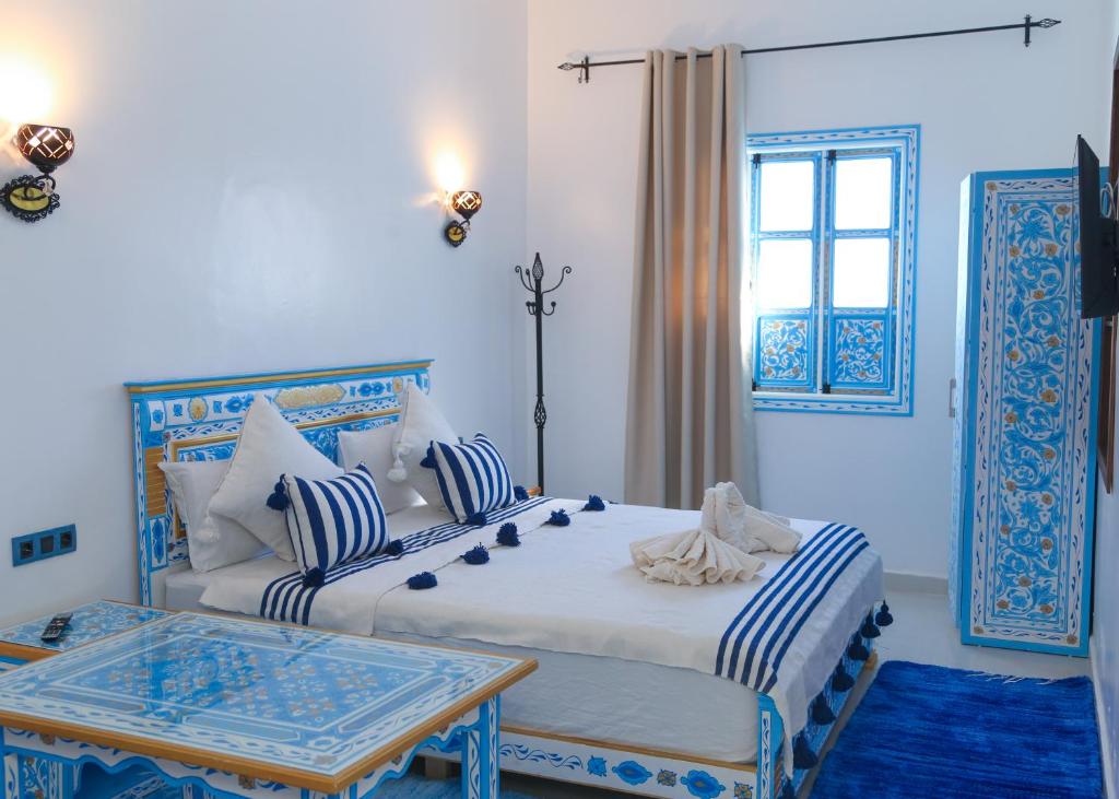 舍夫沙万CASA BLUE PEARL的一间卧室设有两张床、一张桌子和一个窗口