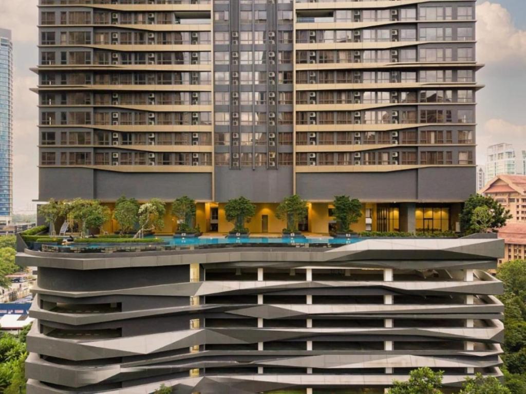 吉隆坡8 Kia Peng Suites KLCC by Luna的一座大建筑的侧面有树木