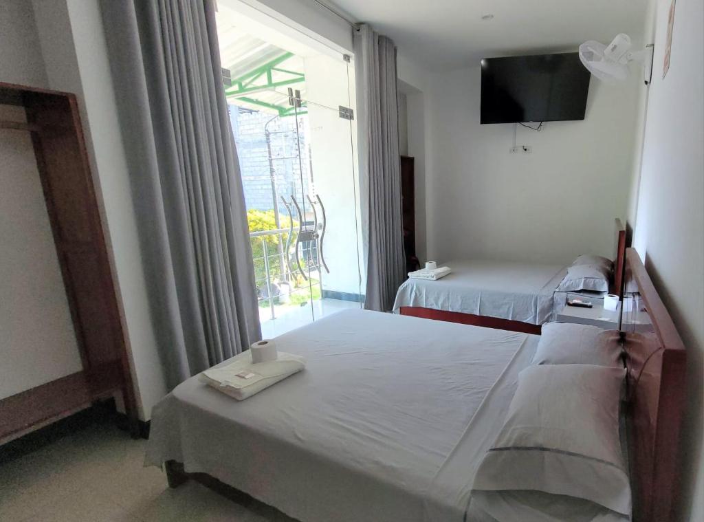廷戈玛丽亚Hospedaje Vista Paraíso的一间卧室设有两张床和大窗户