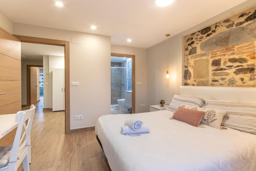 毕尔巴鄂Apartamento El Toisón de Oro 22 Garaje gratis的卧室配有一张白色的大床和石墙