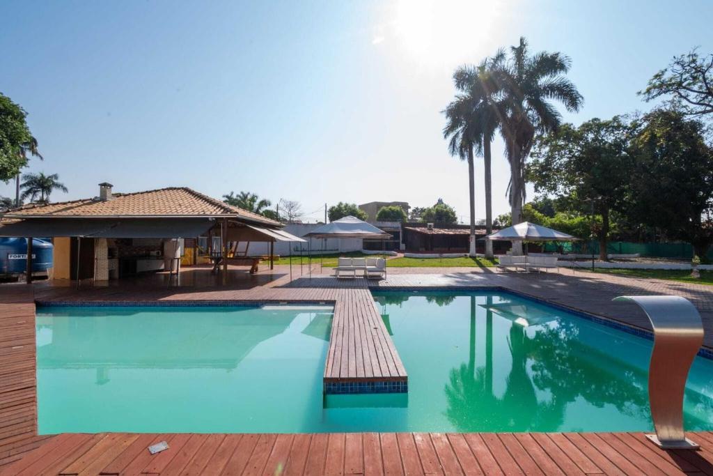 戈亚尼亚Chácara Luxuosa em Goiânia UPR0011的一个带庭院和房子的大型游泳池